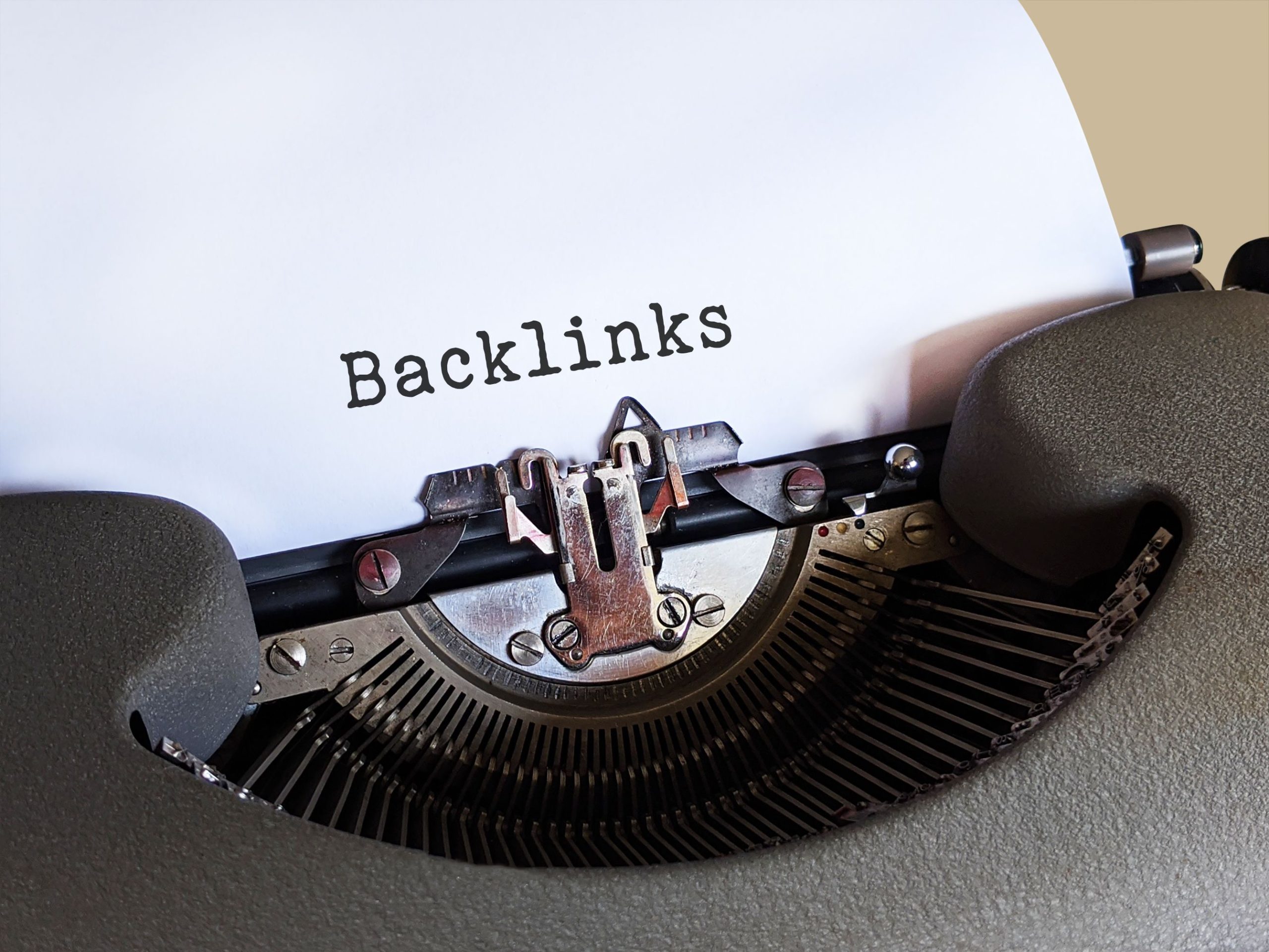 Vintage typewriter printing the word Backlinks, illustrating link building and SEO for online trust