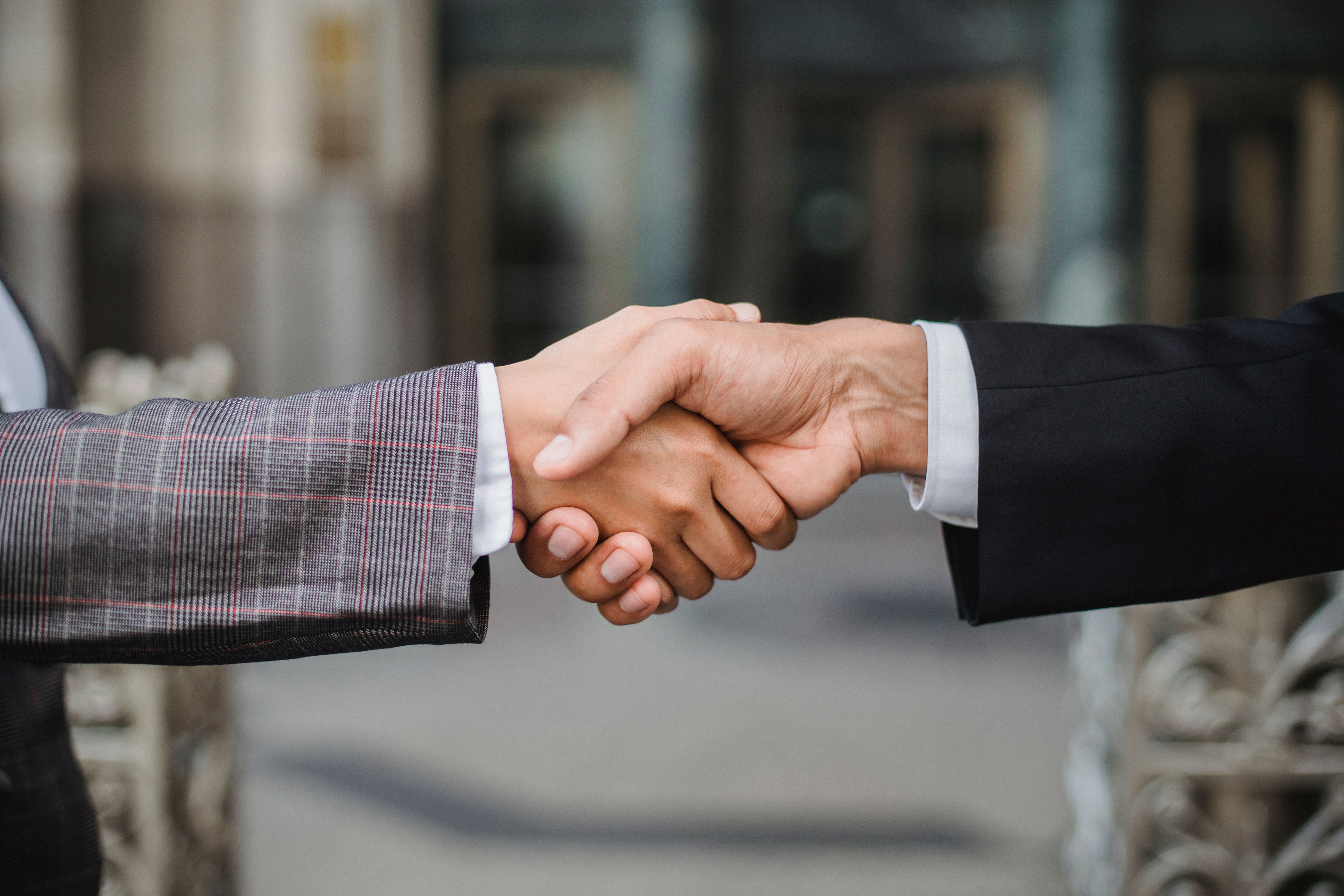 Close-up of two businesspeople shaking hands, symbolizing trustworthy partnerships and referral backlinks