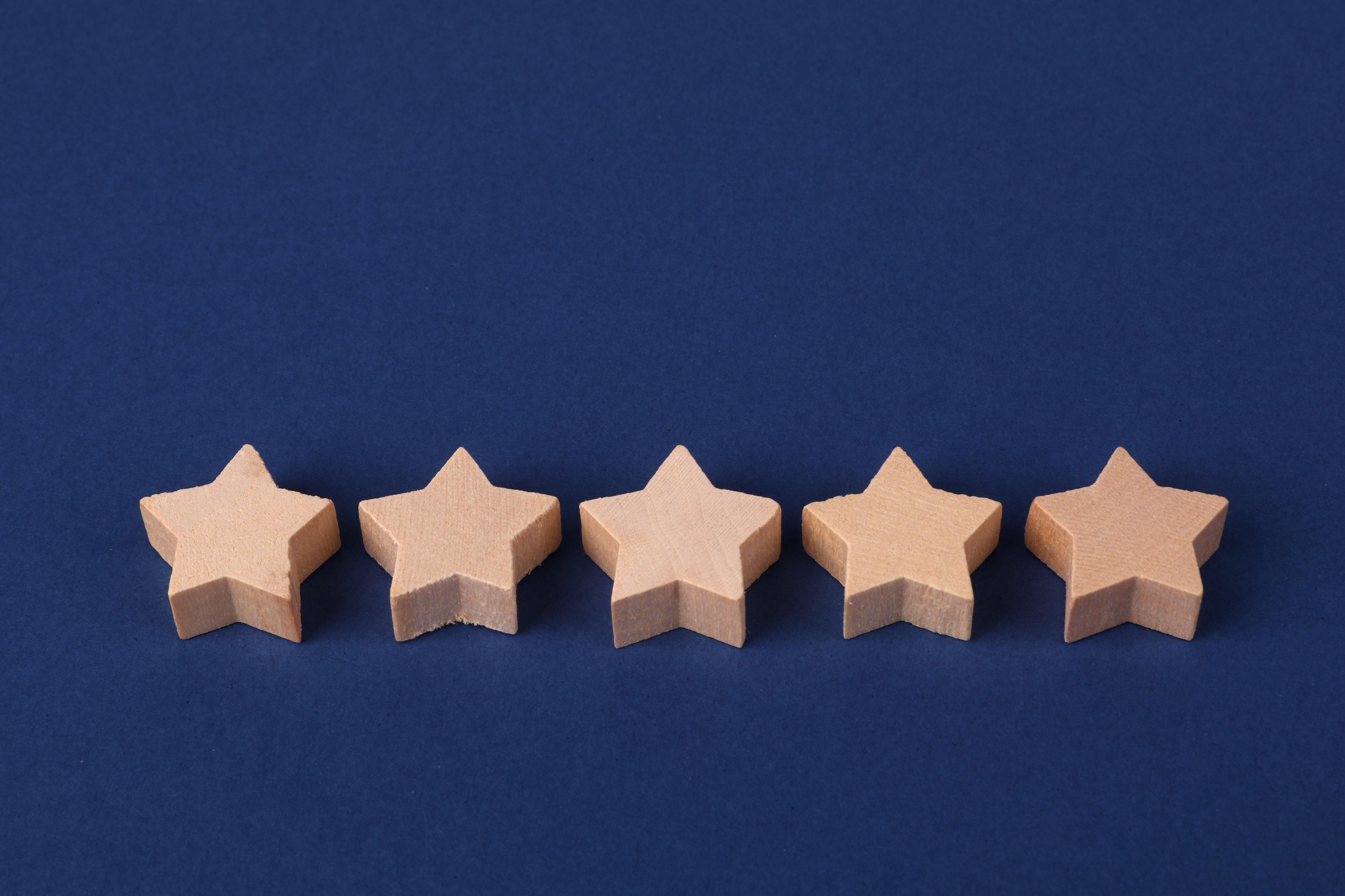 Five wooden stars representing customer reviews and star ratings that build online reputation