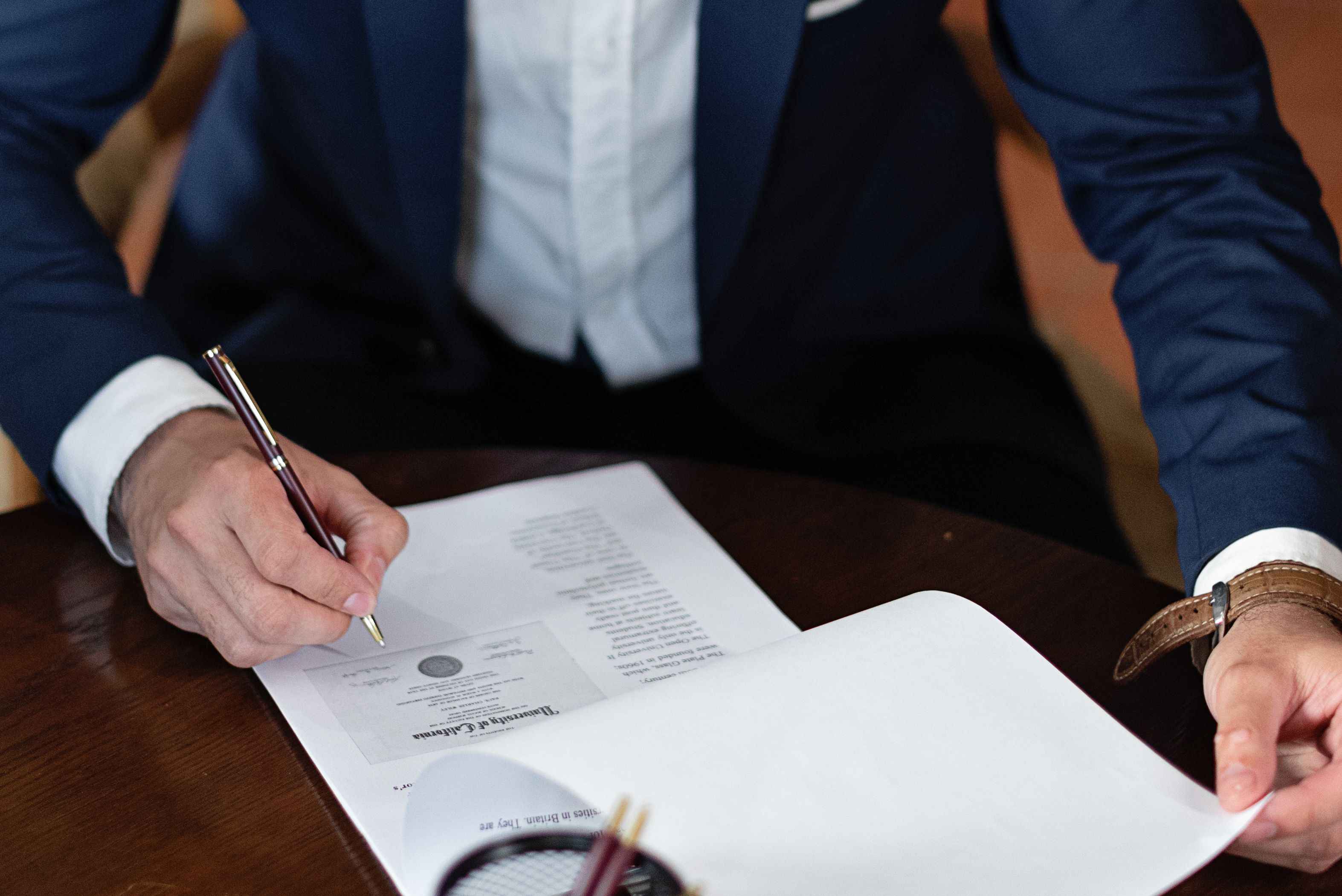 A professional signing a legal funding contract at a desk in an office setting
